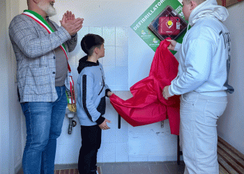 Il momento emozionante in cui i figli di Filippo, Gabriele e Tommaso, procedono insieme al sindaco allo scoprimento del defibrillatore.